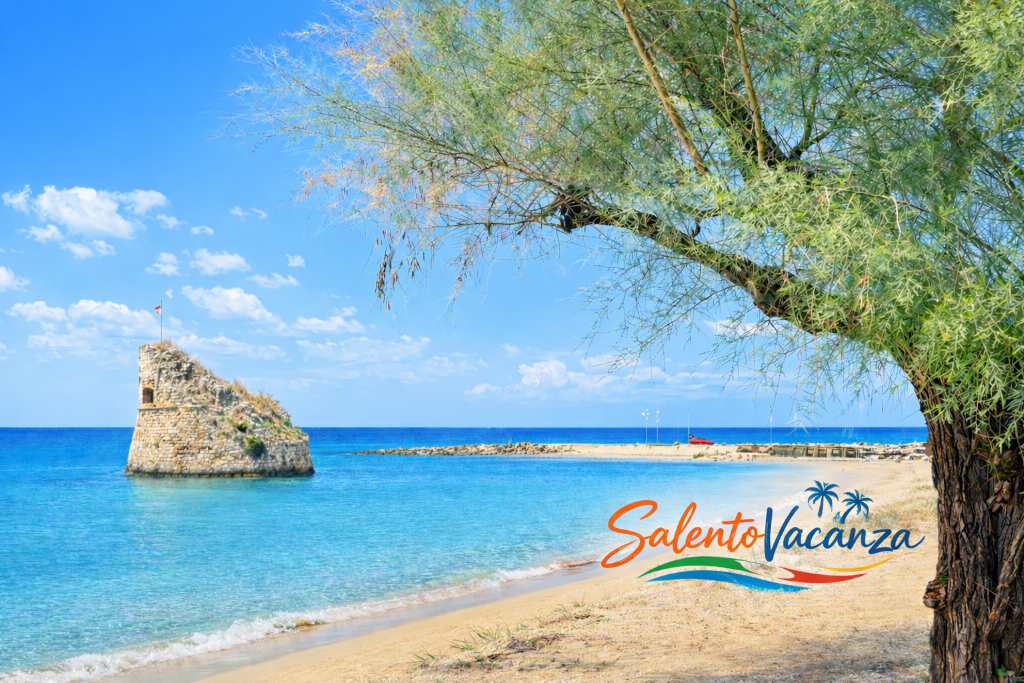 La spiaggia di Torre Pali nel Salento: sabbia dorata e mare cristallino con la torre medievale emergente dall'acqua